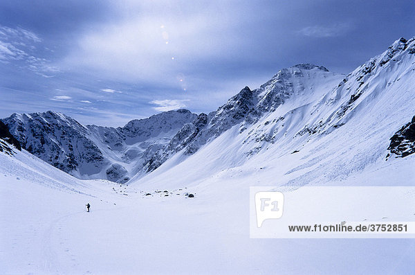 Winziger Skitourengeher in einem weiten verschneiten Hochtal  Stubaier Alpen  Tirol  Österreich  Europa