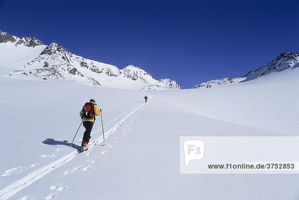 Ski tourer traversing a touring track along a wide snowy high alpine valley to Mt. Similaun  Oetztal Alps  Tyrol  Austria  Europe