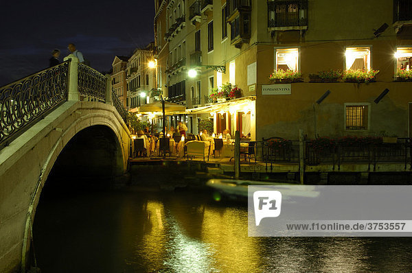 View of a restaurant beside a canal at night  Venice  Venetia  Italy