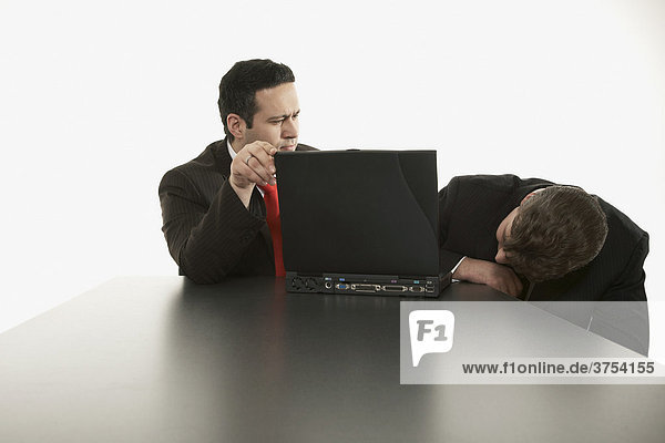 Zwei Geschäftsleute bei der Problemsuche ihres Computers