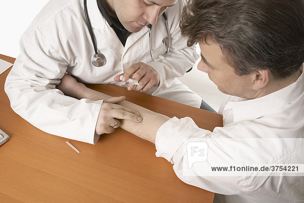 Arzt mit Stethoskop bereitet Injektion am Patienten vor