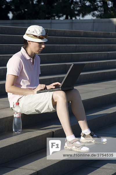 Slowakerin  Frau arbeitet am Laptop auf Treppe