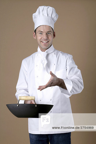 Chef gesturing to wok in his hand
