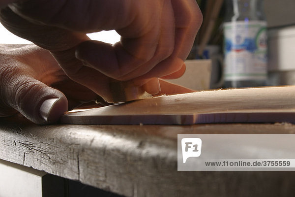 Grinding and sanding  violin-making in a luthier's workshop