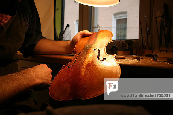 Geigenbauer repariert die Decke einer alten Geige