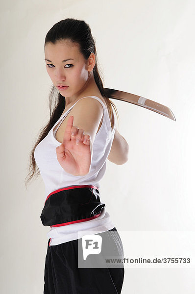 East Asian girl practicing Kung Fu with sword  rage  vengeance