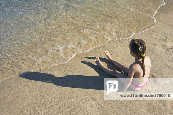 Kleines Mädchen sitzt am Strand  Sardinien  Italien