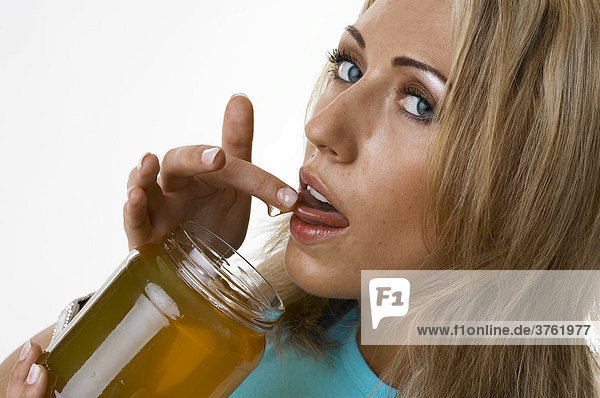 A young woman is nibbling honey