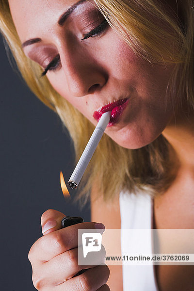 Woman lights a cigarette