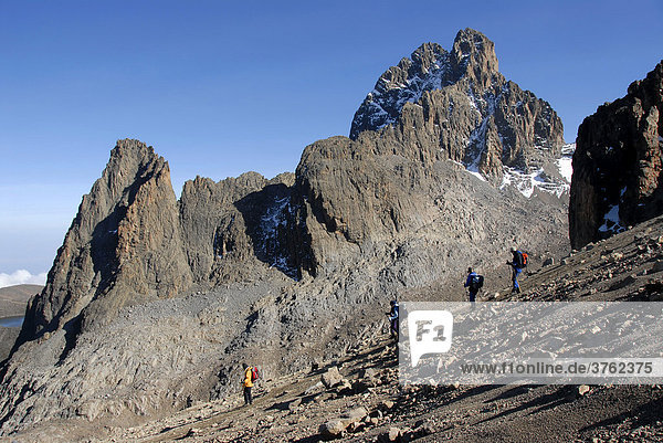 Group of mountaineers walk down a slope summit Batian (5199 m) and Nelion (5188 m) Mount Kenya National Park Kenya