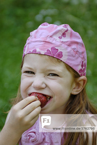 Kind beim Erdbeeren essen