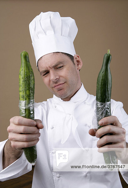 Cook looking sceptical at two cucumbers