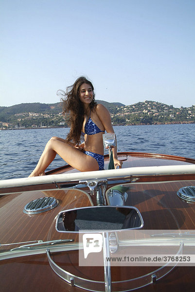 Junge Frau im Bikini sonnt sich auf der Bugspitze eines Riva Motorboots  ThÈoule-sur-Mer  Frankreich  Europa