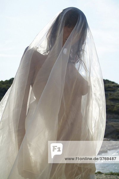 Nackte,  junge Frau am Strand in ein durchsichtiges Tuch gehüllt,  Mallorca,  Spanien