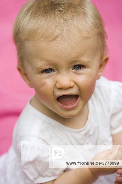 Portrait eines 10 Monate alten Mädchens beim Spielen