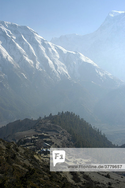 Blick auf das Dorf Ngawal mit dunstigem Tal und schneebedeckten Bergen Annapurna Region Nepal