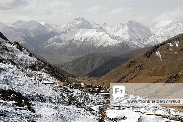 Dorf auf schneebedecktem Hang und Berge Yerpa Tibet China