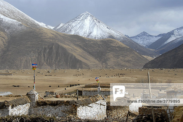 Dorf vor schneebedeckten Bergen am Kloster Reting Tibet China