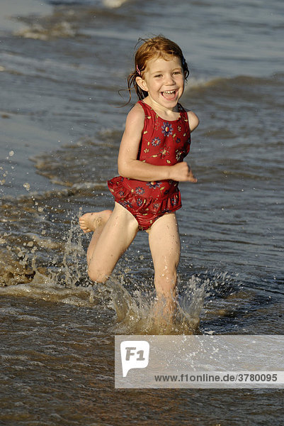 Little girl running along the beach