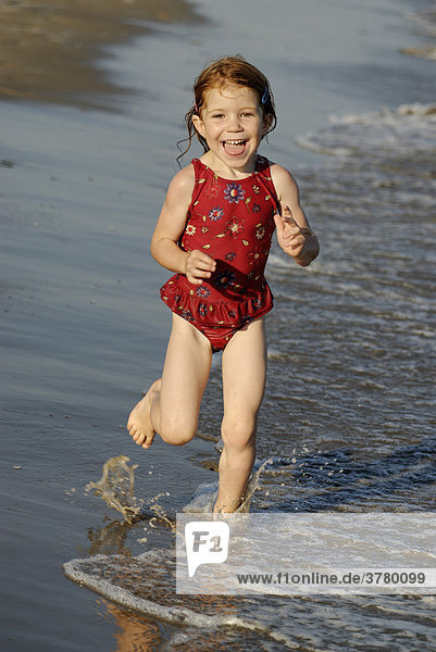 Kleines Mädchen läuft am Strand