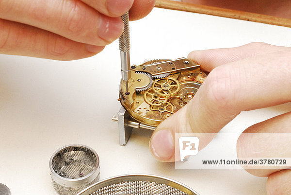 Uhrmacher reinigt eine Taschenuhr