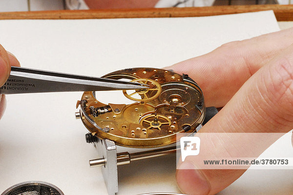 Uhrmacher reinigt eine Taschenuhr