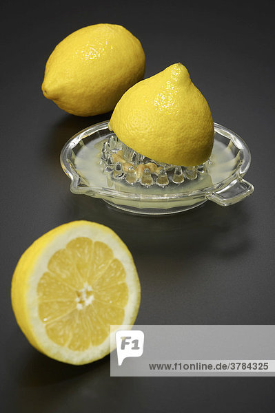 Zwei Zitronen mit Saftpresse aus Glas
