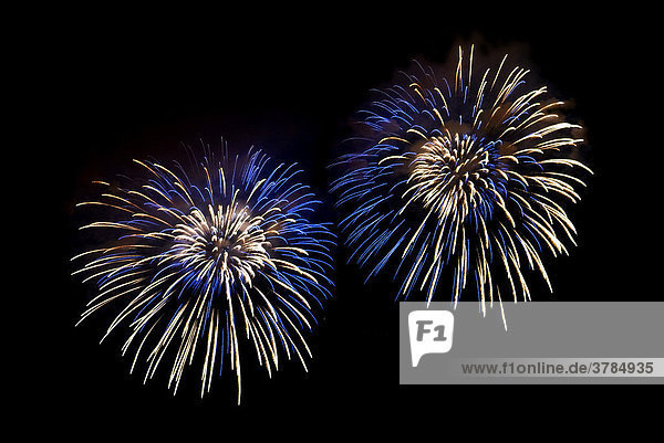 Blau-weiße Lichteffekte im Nachthimmel beim Feuerwerk zu Silvester