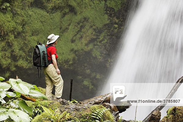 Frau vor Wasserfall in Privatreservat Arenal Observatory Lodge  Region Arenal  Costa Rica