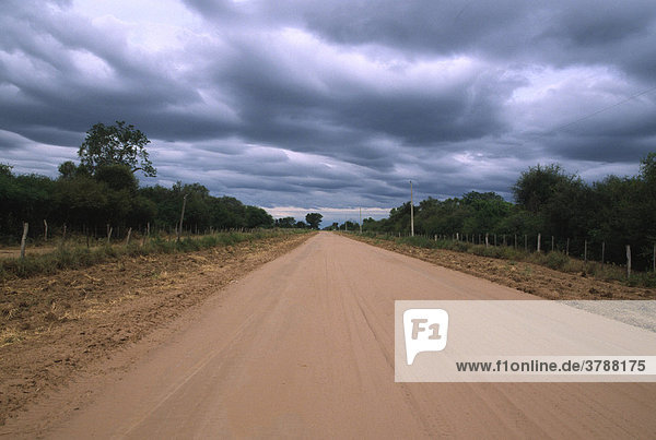 Das Ende der Trockenzeit: Wolkenverhangener Himmel über einer Landstraße  Gran Chaco  Paraguay