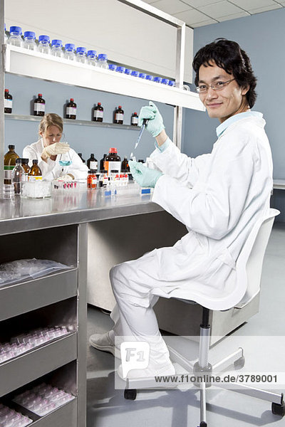 Two lab technicians working in a laboratory  focus on man in foreground