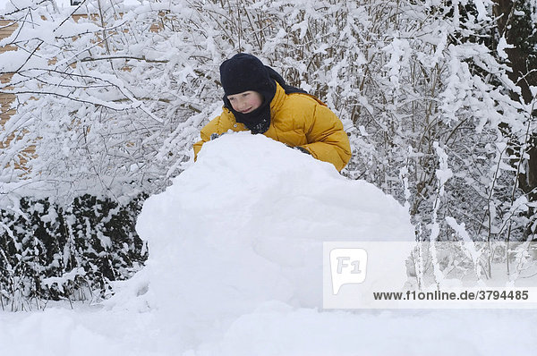 8 year old boy building a snow man