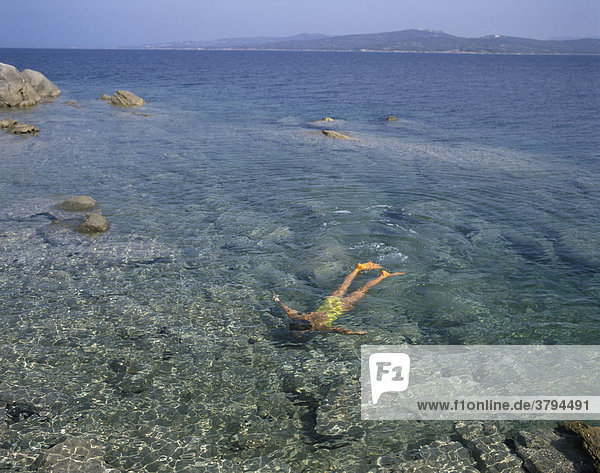 Junge Frau taucht im flachen Wasser Sardinien Italien