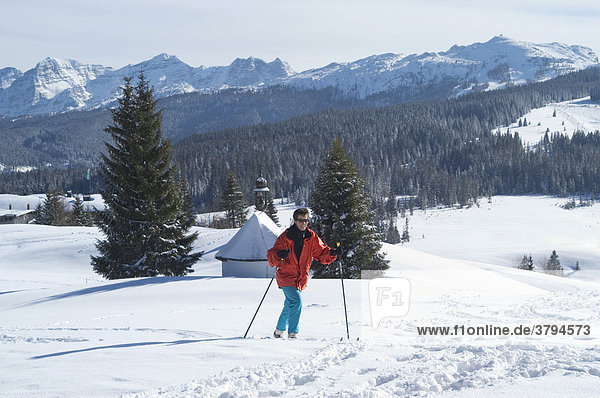 Cross-country skier in front of Chapel at the Winkelmoosalm Upper Bavaria Germany in the background Mount Steinplatte Tirol Austria