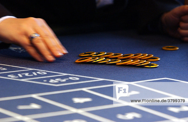 Spiel Casino im 37. Stock des Forum Hotel in Berlin Mitte. Haende beim Sortieren von Chips beim Roulette.