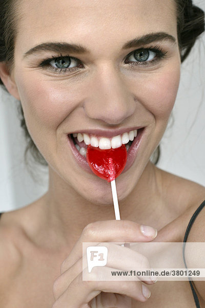 Portrait einer jungen Frau essen Süßigkeiten lollipop