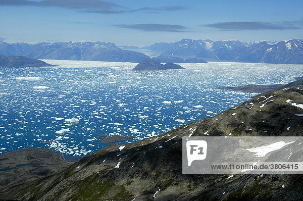 Weiter Blick über Felsen auf Eisberge Gletscher und Berge Sermilik Fjord Ostgrönland