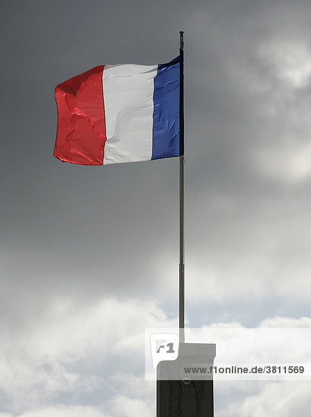 Die franzoesische Fahne vor dunklem Himmel