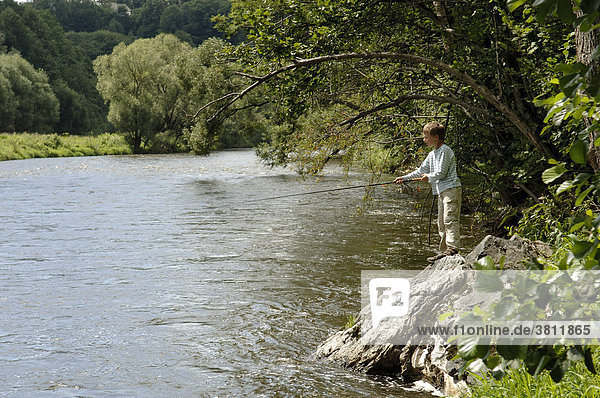 Nine-year-old boy fishing  Vltava river near Zlata Koruna  South Bohemia  Czech Republic