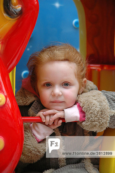 Small girl in the children's merry-go-round