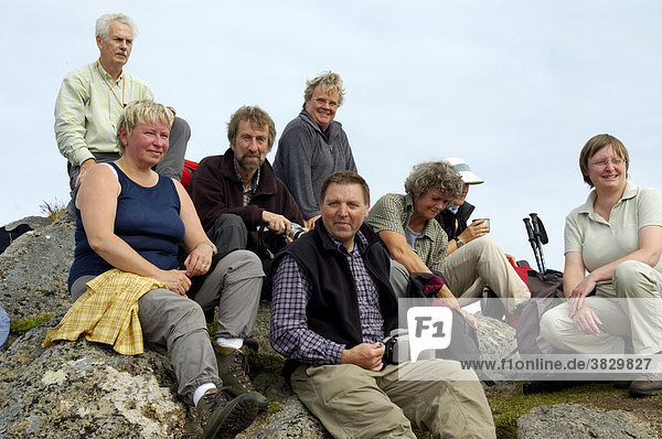 MR Group of hikers enjoy the rest on the summit Munkan Vestvagoya Lofoten Norway