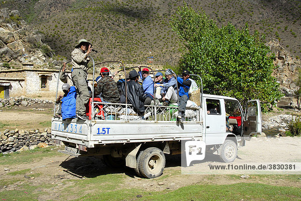 Trekkinggrupe drängt sich mit Gepäck auf der Ladefläche eines chinesischen LKW Nyango Tibet China
