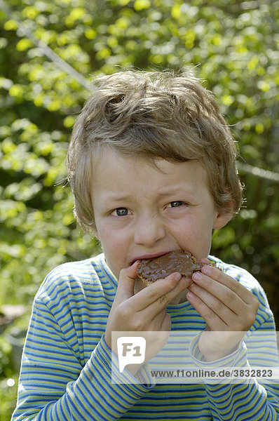 Ein siebenjähriger Junge isst Schokoladenbrot