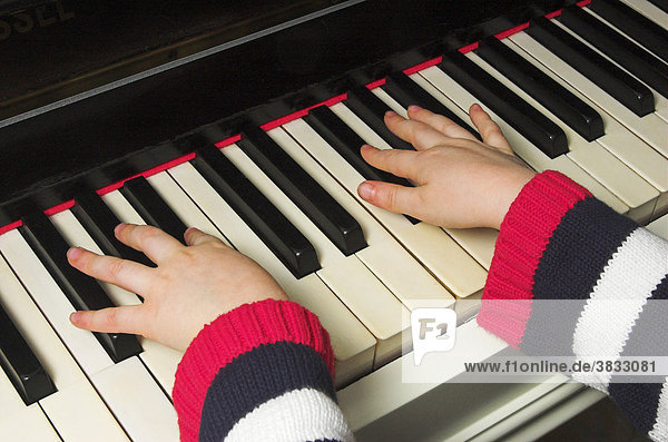 Hands of a little girl playing the piano