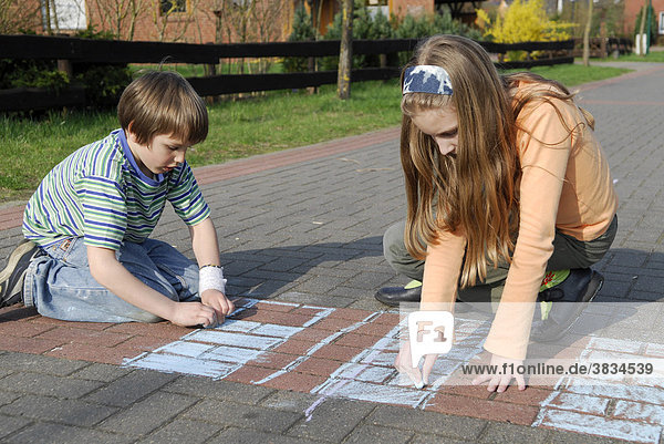 Children paint with chalk on the road