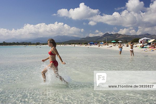 Frau läuft ins Wasser am Strand Cala Brandinchi Ostküste Sardinien