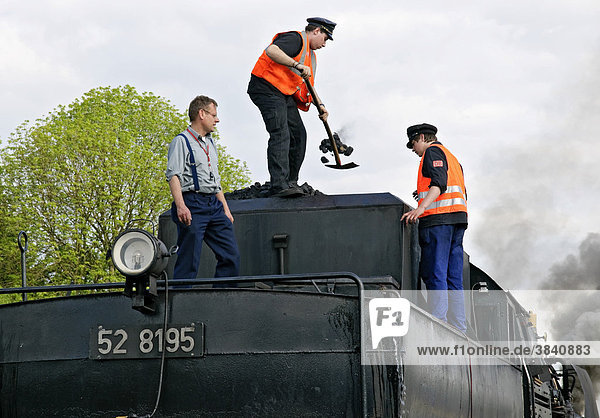 Männer befeuern Dampflokomotive mit Kohle  Deutsches Dampflokomotiv-Museum  Neuenmarkt  Franken  Bayern  Deutschland  Europa