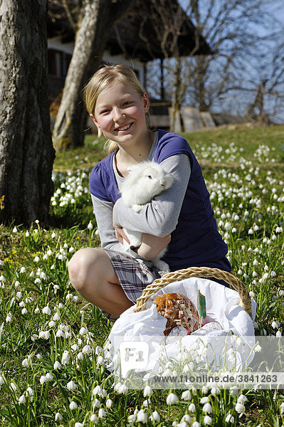 Girl holding a rabbit in her arms  with an Easter basket  Easter bunny