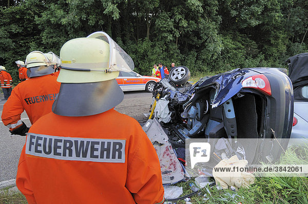 Ein Feuerwehrmann vor dem Wrack des Kleinwagens Renault Clio  in dem auf der B 39 drei Menschen ums Leben kamen  Kirchardt  Baden-Württemberg  Deutschland  Europa