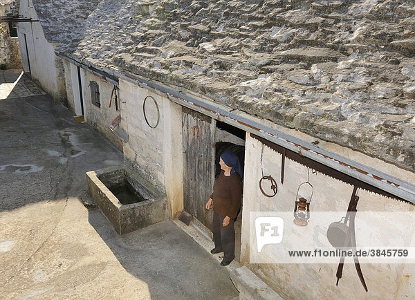 Old woman at the entrance to her stone house Skrip Brac island Croatia Europe